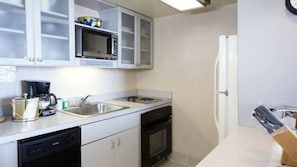 Cocina compacta equipada con microondas, horno y lavavajillas.