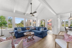 A spacious living room with a sectional sofa, a coffee table, and a view of the outdoors. - Renovated on the Lagoon within Walking Distance to the Beach &
Amenity Cards! (Seabrook Island)