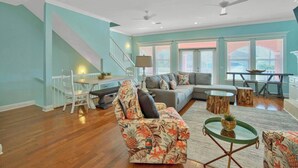 A spacious living room with a sectional sofa, a round coffee table, and a dining area with a table and chairs. - Steps to Beach-Ocean views with both lake & pool (Panama City Beach)