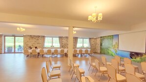 A spacious conference room with a long table and chairs, large windows, and a projector screen. - Źródlo Raduni (gmina Stezyca)