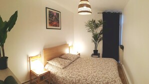 A bedroom with a bed, bedside lamps, a framed picture on the wall, and two potted plants. - Résidence du Parc des Tilleuls de LYON (4 bdrms, 82m²,free pkg, EUREXPO) (Lyon)