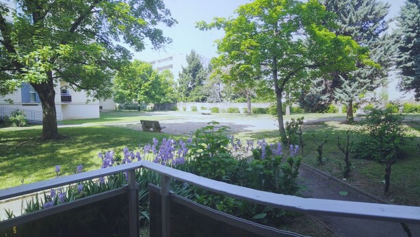 A courtyard with a bench, trees, and a building in the background. - Résidence du Parc des Tilleuls de LYON (4 bdrms, 82m²,free pkg, EUREXPO) (Lyon)