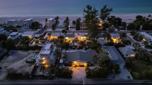 An aerial view of a coastal residential area with houses, a beach, and a clear sky. - Charming Ground Level Resort Style 3 unit Condo  - unit C (Holmes Beach)