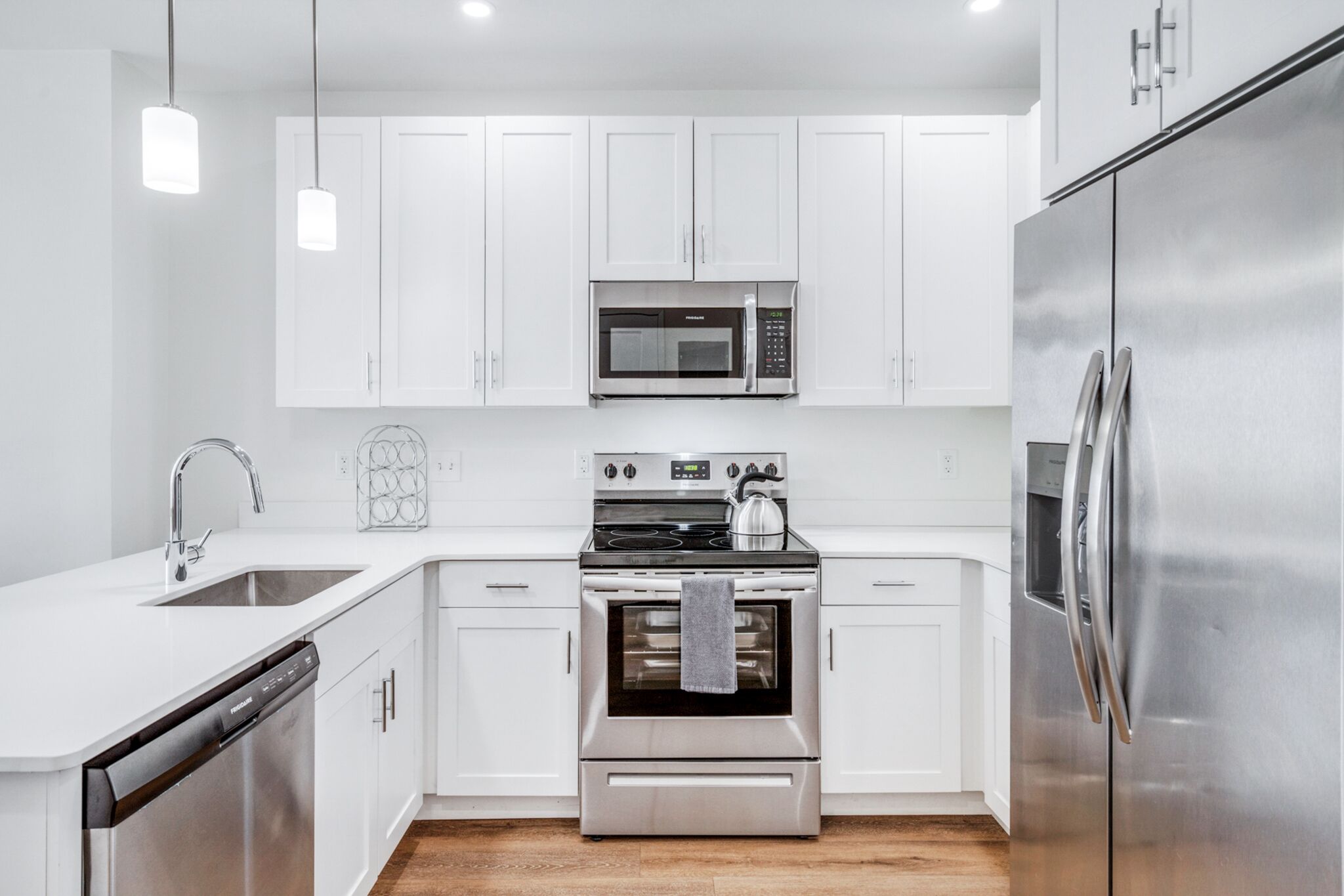A modern kitchen with white cabinets, stainless steel appliances, and a dishwasher.
