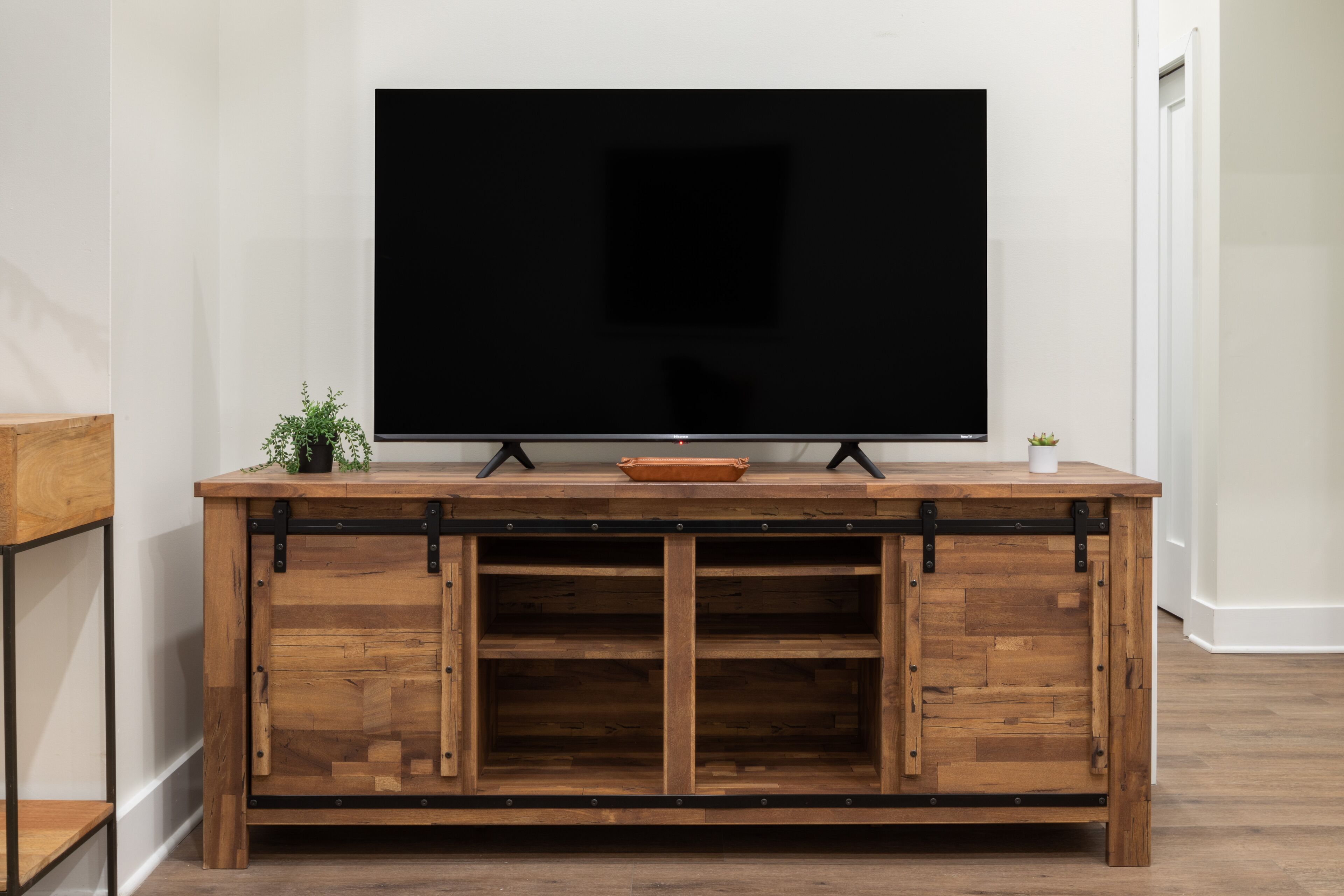 A wooden entertainment center with a flat-screen TV mounted above it.