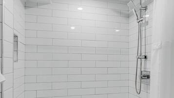 A modern shower with a rain showerhead, a handheld showerhead, and a glass-enclosed shower area.