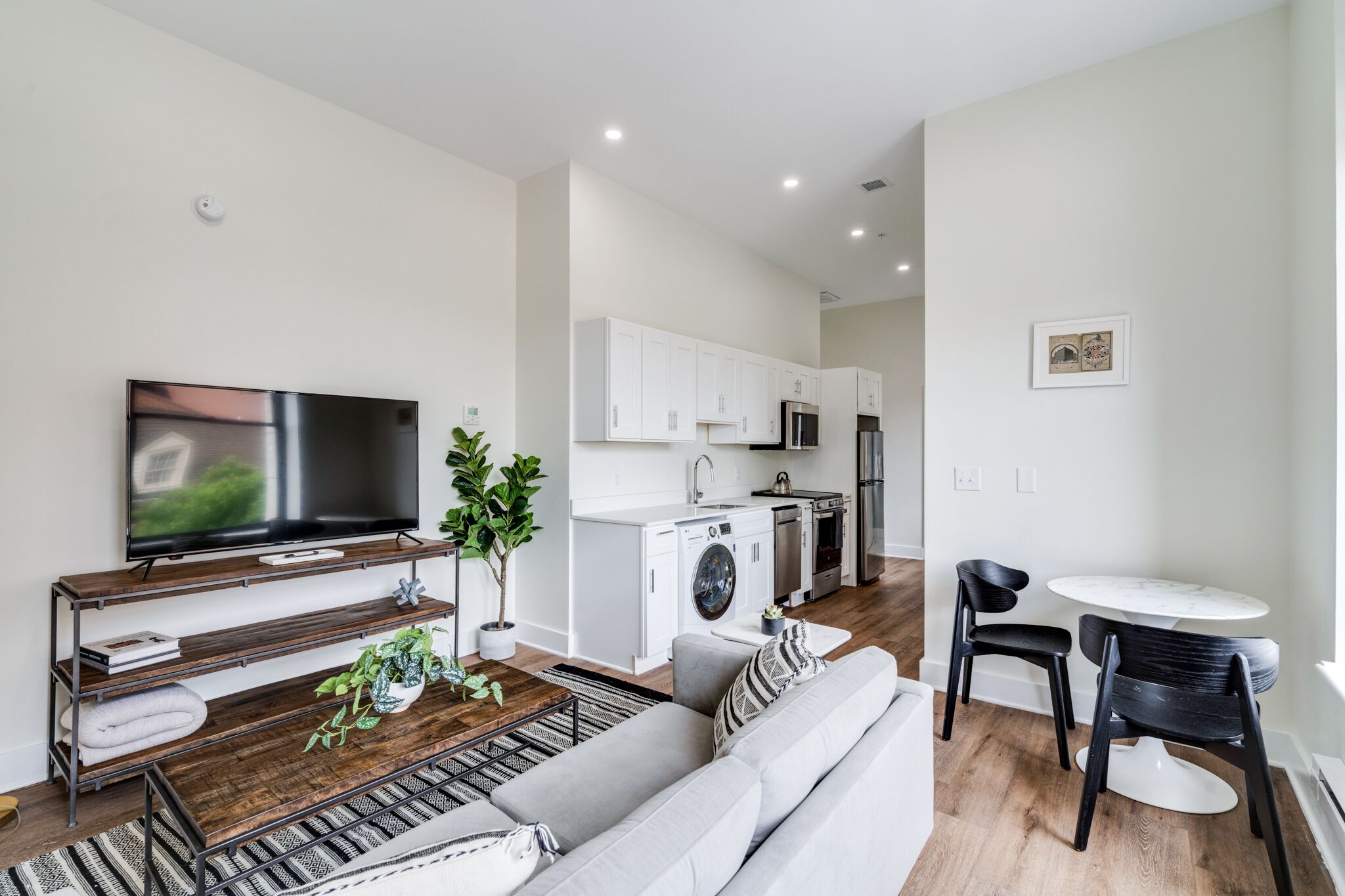 A modern apartment with a living room, kitchen, and dining area.