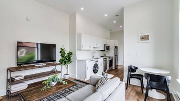 A modern apartment with a living room, kitchen, and dining area.