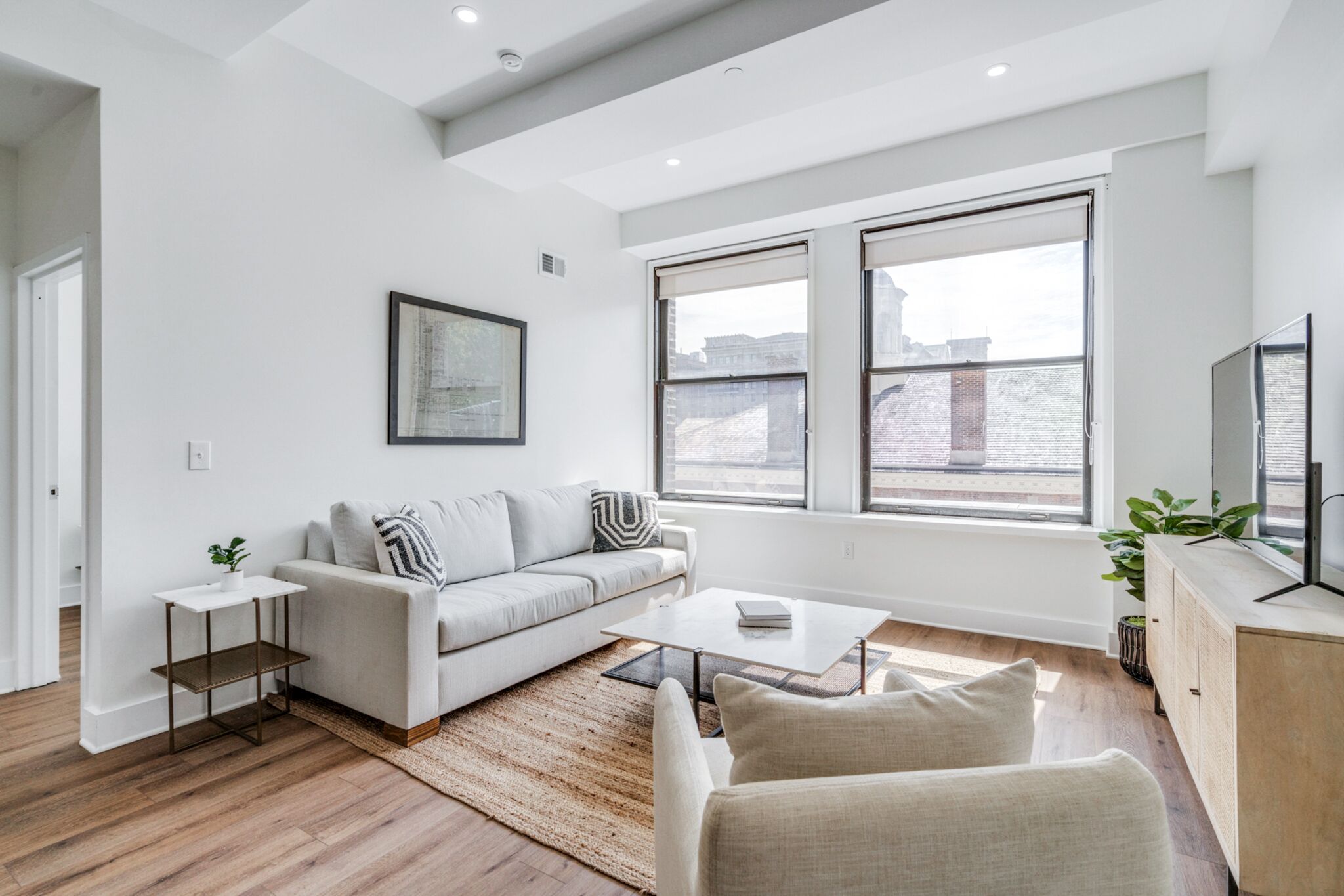 A modern living room with a sofa, coffee table, and a TV.