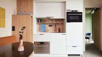 A modern kitchen with white cabinets, a Bosch oven, and a sink.