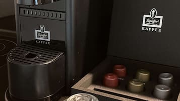 A coffee machine and a box of coffee pods on a countertop.