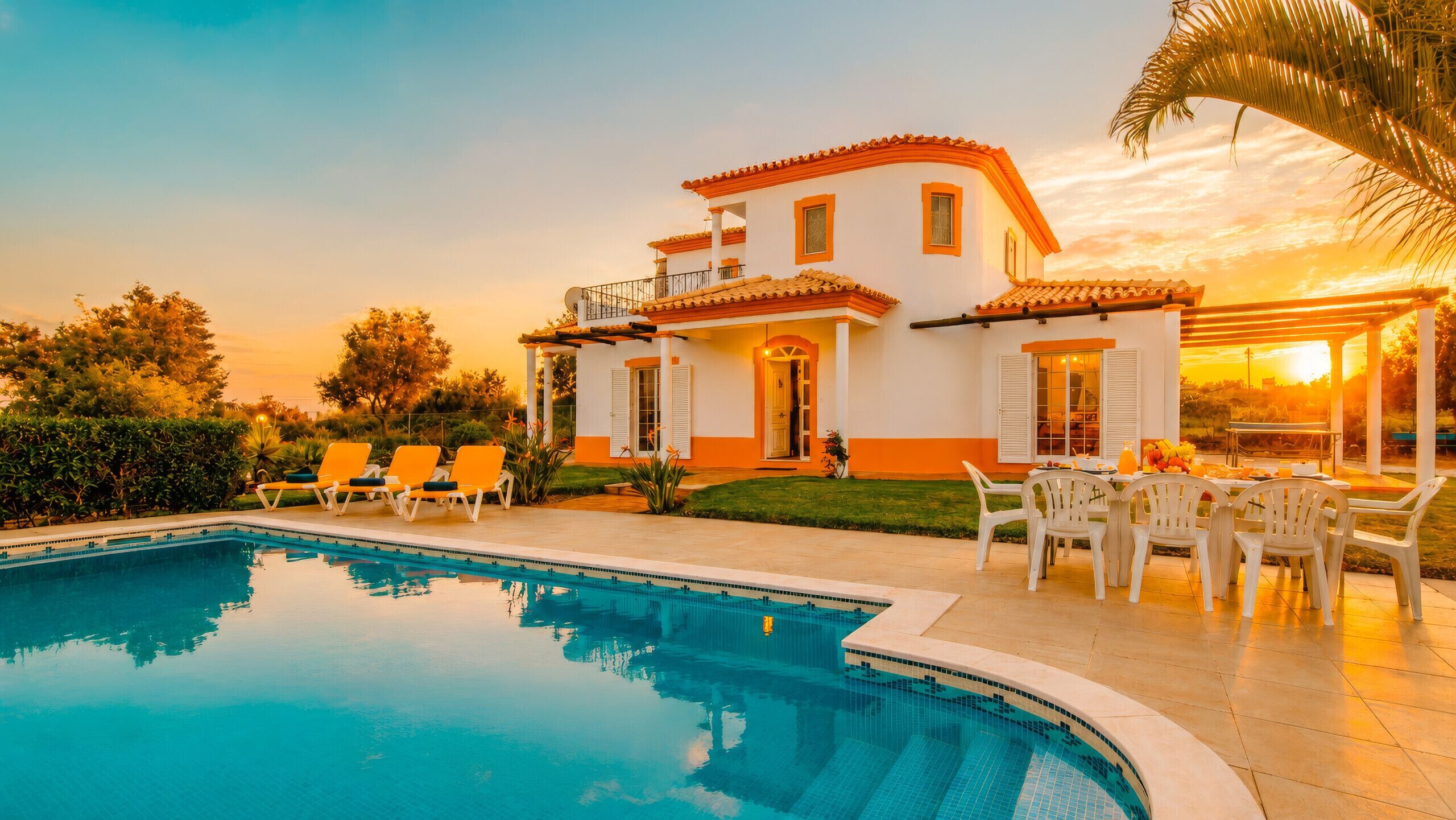 A two-story house with a swimming pool, outdoor seating, and a patio area.