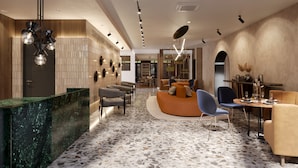 A modern interior with a reception desk, seating area, and a bar.