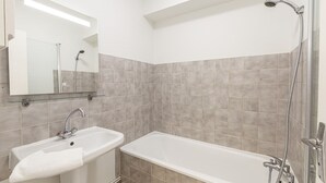 Ein Badezimmer mit Waschbecken, Spiegel und Badewanne.