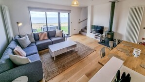 A modern living room with a sofa, TV, and fireplace.