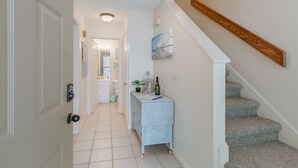 A hallway with a white door, a light blue cabinet, and a staircase with carpeted steps.