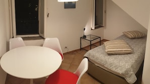 A small room with a bed, a table, and two chairs.