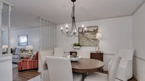 A dining area with a round table, white chairs, and a chandelier. - Walking distance to the Augusta National and Surrey Center (Augusta)
