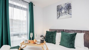 A hotel room with a bed, a breakfast tray, a painting, and a window with curtains. - Watford Cassio Luxury - Modernview Serviced Accommodation (Watford)
