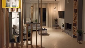Ein modernes Wohnzimmer mit einer Couch, einem Couchtisch, einem Kamin und einem an der Wand befestigten Fernseher.
