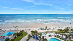 A resort with a pool, beach, and ocean view.
