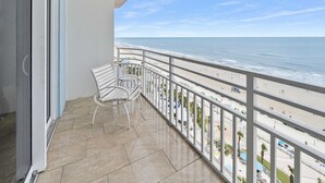 A balcony with a view of the beach and ocean.