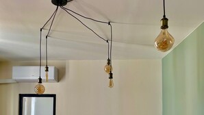 A room with a bed, a small table, and hanging light fixtures. - T3 5min from the beaches and creeks, FREE secure parking ! (La Ciotat)