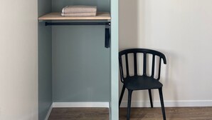 A room with a built-in shelving unit against a wall, a black chair, and wooden flooring. - T3 5min from the beaches and creeks, FREE secure parking ! (La Ciotat)