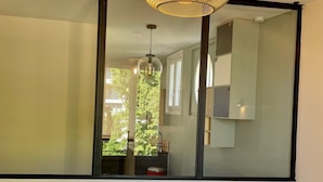 A modern bedroom with a large window, a bed with a white headboard, two bedside tables, and a hanging light fixture. - T3 5min from the beaches and creeks, FREE secure parking ! (La Ciotat)