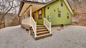 A green building with a porch and steps leading to a door. - Want to REALLY get away? Round Bottom Roost. Secluded. Close to everything. (Mountain View)
