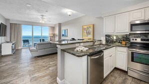 A modern kitchen with white cabinets, a granite countertop, and stainless steel appliances. - Luxury 5th Floor 3 BR Condo Direct Oceanfront Wyndham Ocean Walk Resort Daytona Beach | 504 (Daytona Beach)