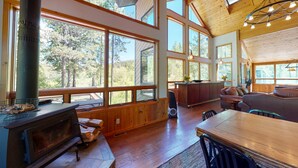 A spacious cabin with large windows, a fireplace, and a cozy seating area. - 40-acre haven on the banks of the Fall River (Ashton)