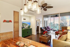 Relax in this inviting living area with a dining table for four, comfortable sofa, and large window offering a view of the outdoors.