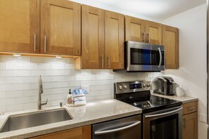 Enjoy cooking in this well-equipped kitchen with a double sink, microwave, toaster, and oven.