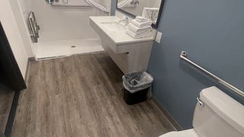 A modern bathroom with a shower, toilet, and sink.