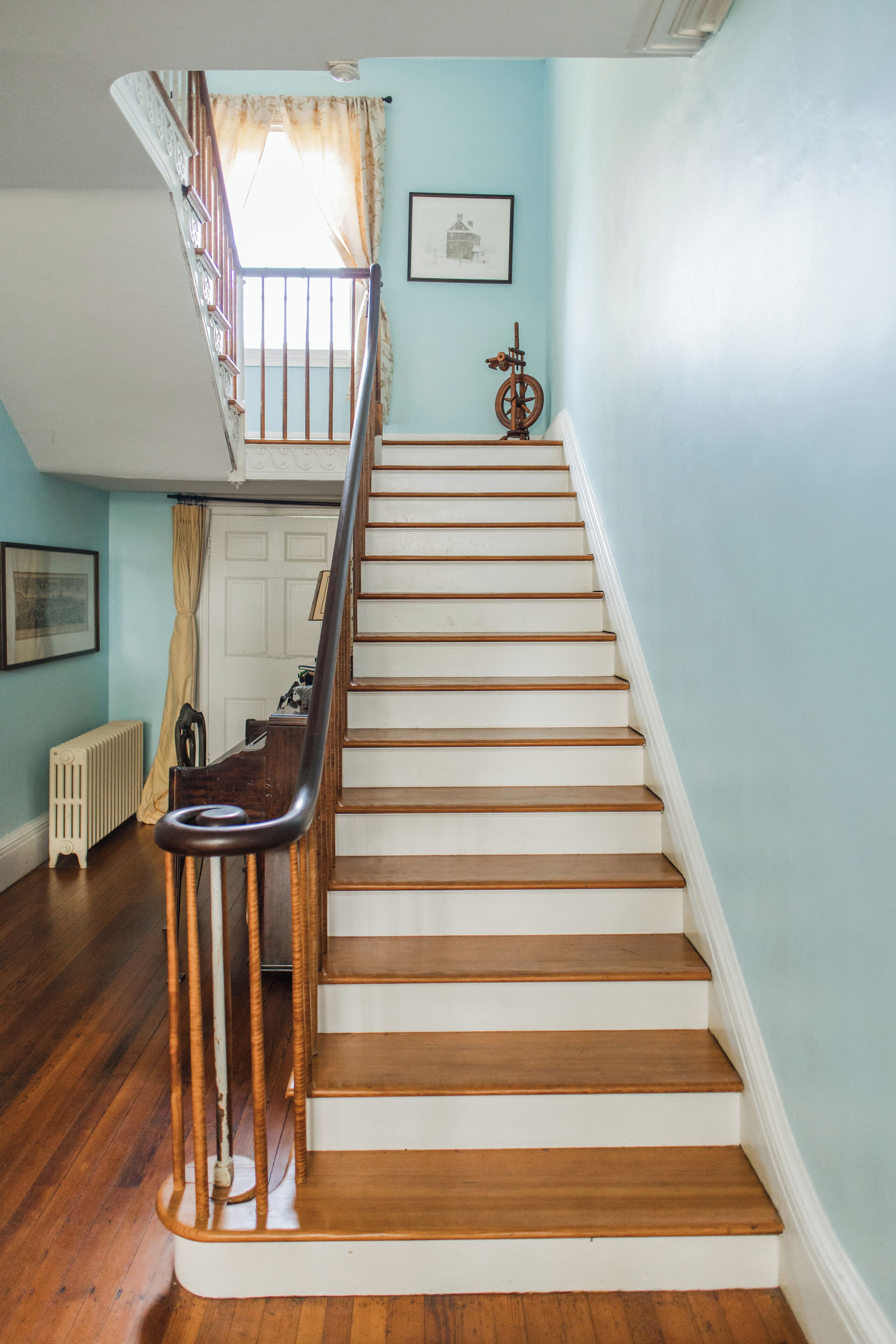 A staircase with wooden steps and a handrail, leading to an upper floor.