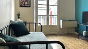 Une chambre à coucher avec un lit, une fenêtre donnant sur un beau paysage, un radiateur et un meuble pour la télévision.