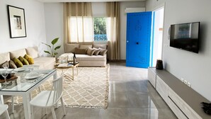 Un salon moderne avec un canapé, une table basse et un coin repas.