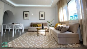 Un salon moderne avec un canapé, une table basse et un coin repas.
