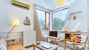 Una sala de estar acogedora con chimenea, televisor y comedor.