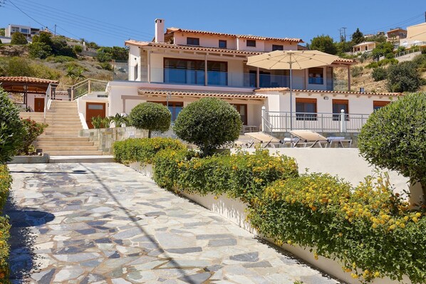 A two-story building with a stone pathway leading to a staircase.