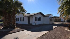 A single-story house with a front porch, a garage, and a small driveway.