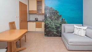 A compact living space with a kitchenette, a dining area, and a sofa with a view of the sea. - Apartments Antonio - Studio with Balcony (2+1) - 5 (Tucepi)