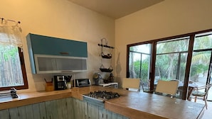 Una cocina con una isla central, microondas y cafetera.