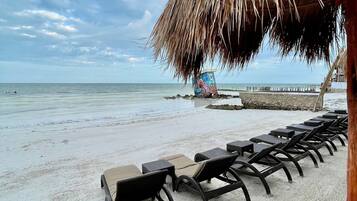 On the beach, white sand, sun loungers, beach towels