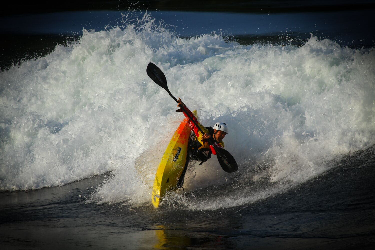 A kayaker navigating a wave.