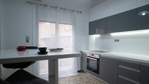 A modern kitchen with a white countertop, grey cabinets, and a built-in oven. - Modern design - Lux 1 B Apart. -15 m. from Acropolis! (Athina)