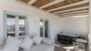 A modern outdoor living area with a white sofa, a table, and a bench.