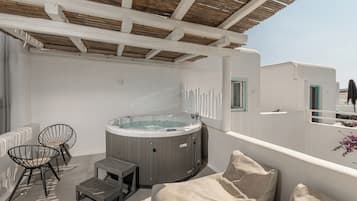 A rooftop terrace with a hot tub, seating area, and a view of the city.
