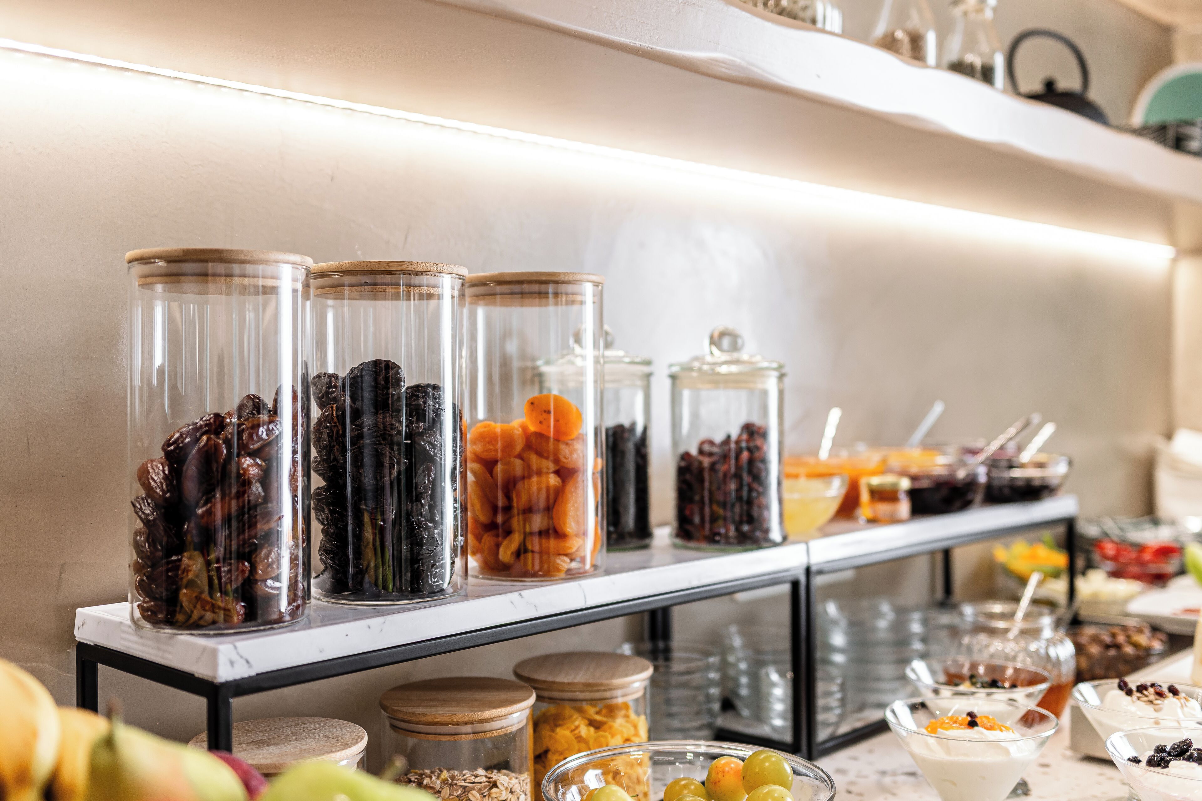 Een buffet met diverse soorten eten in glazen schalen en kommen.